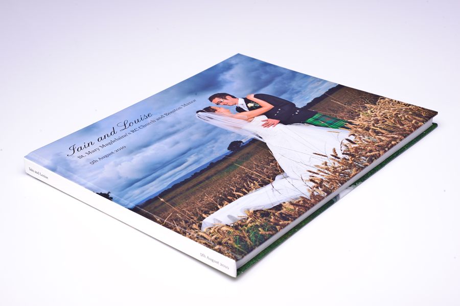 D3A_9224-copy | Weddings by Michael Wedding photo album showing a bride and groom embracing in a field, with the names Jain and Louise on the cover.
