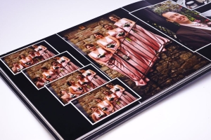 Photo album spread with several small wedding party pictures in pink dresses surrounding a larger central image on a stone staircase.