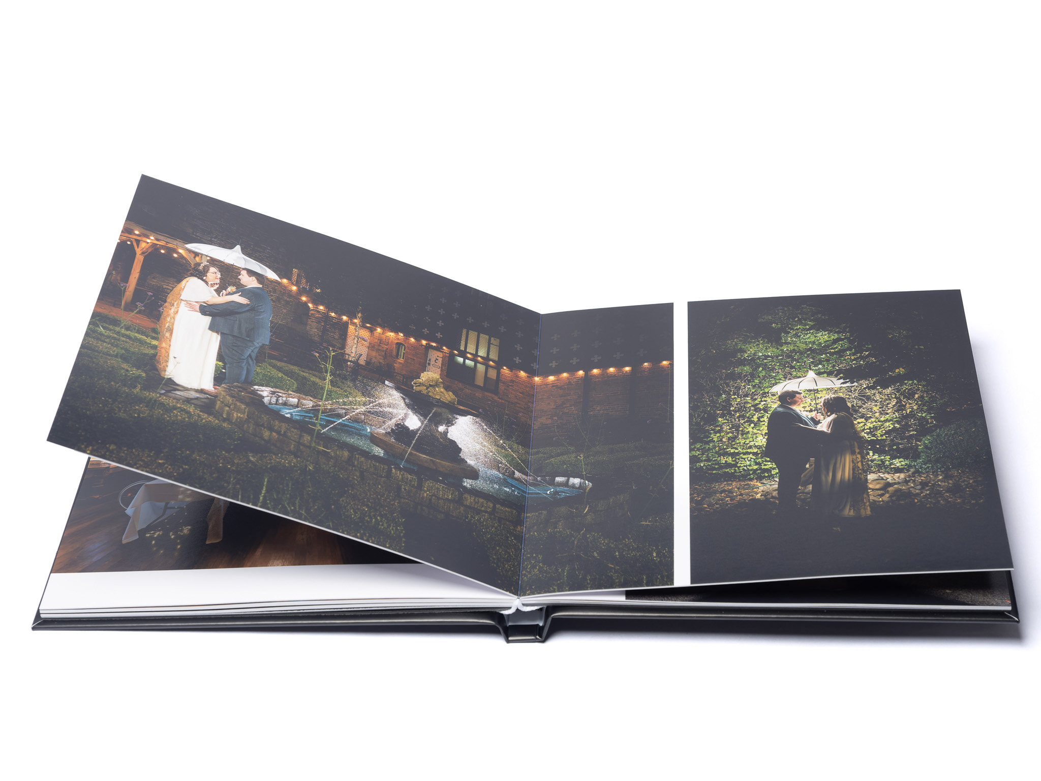 MemoryAlbum_03 | Weddings by Michael Open photo album displaying wedding photos of a couple embracing outdoors at night; string lights in the background.
